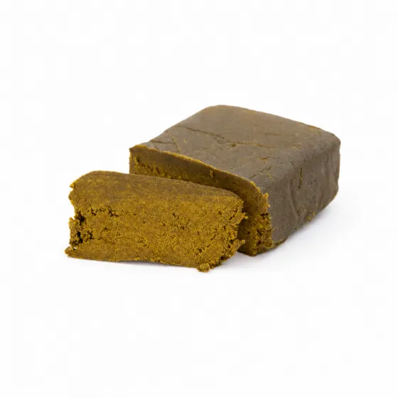 Hachís Nepal Dry CBD en bloque, con interior ocre-dorado y textura fina sobre fondo blanco