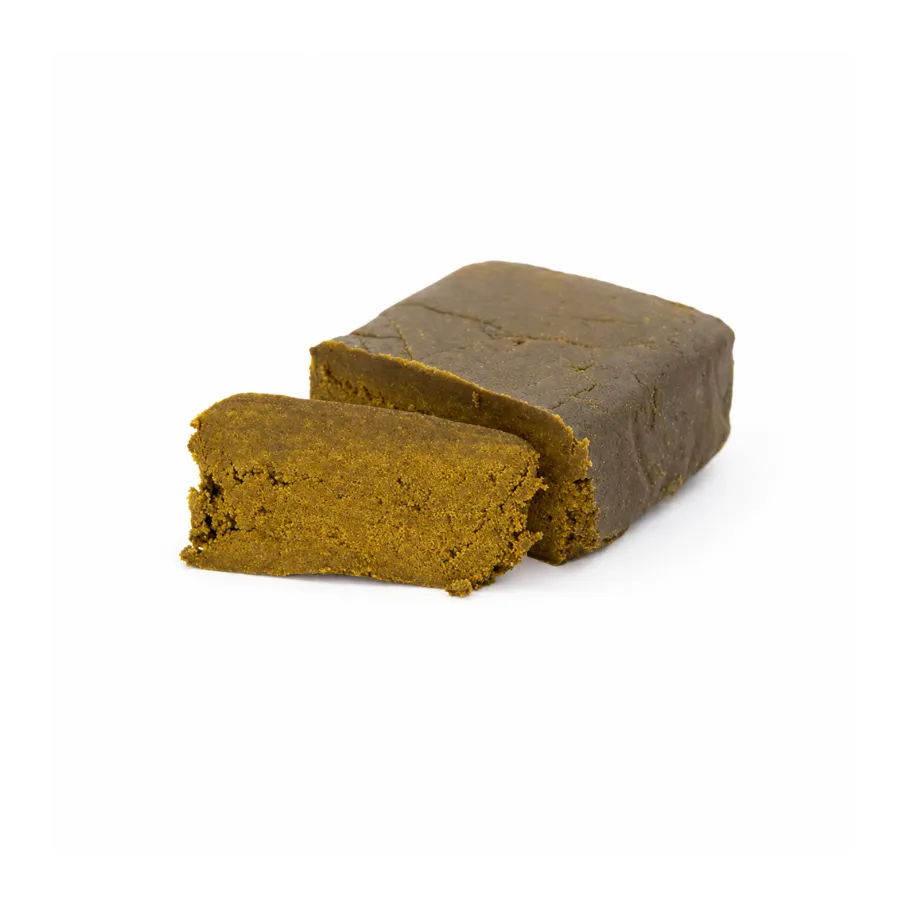Hachís Nepal Dry CBD en bloque, con interior ocre-dorado y textura fina sobre fondo blanco